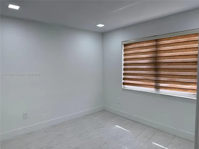 a view of hallway with a white floor and cabinet