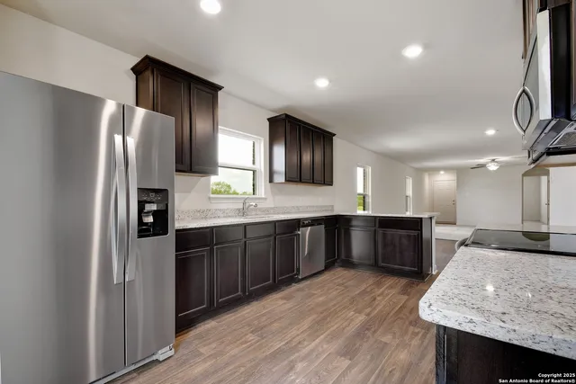 a large kitchen with a large counter top sink appliances and cabinets