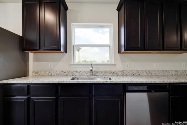 a kitchen with a sink a counter top space and cabinets
