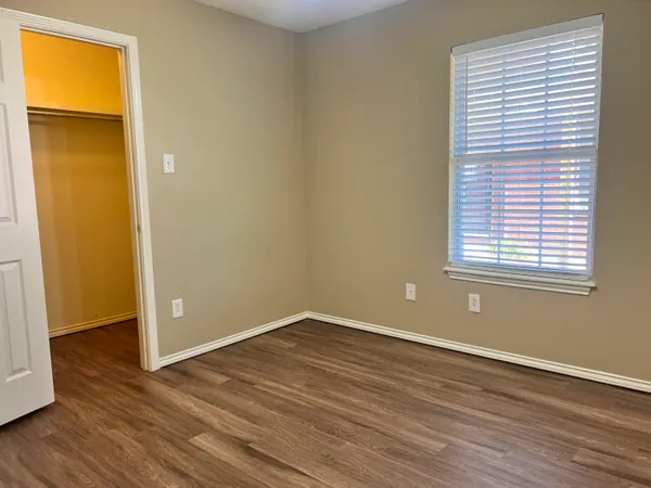 an empty room with wooden floor and a window