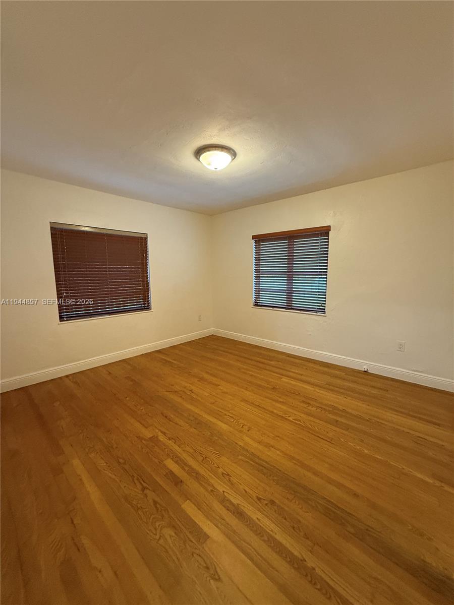 2151 Southwest 21st Terrace Miami, FL 33145 - Photo 11 of 22 a view of an empty room with wooden floor and a window