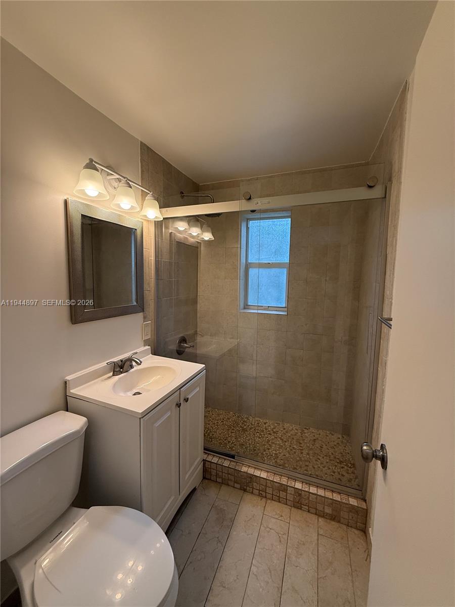 2151 Southwest 21st Terrace Miami, FL 33145 - Photo 14 of 22 a bathroom with a sink a toilet a mirror and shower