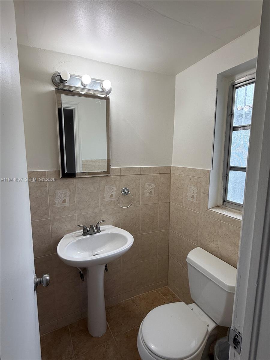 2151 Southwest 21st Terrace Miami, FL 33145 - Photo 18 of 22 a bathroom with a toilet sink and mirror