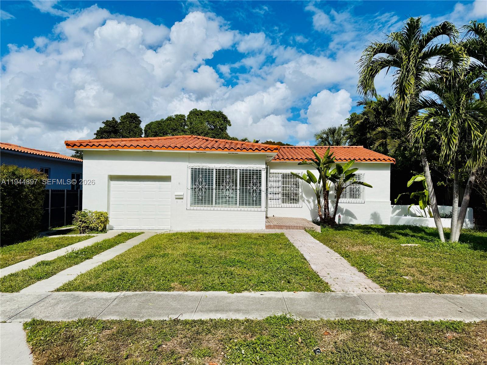 2151 Southwest 21st Terrace Miami, FL 33145 - Photo 2 of 22 a front view of a house with a yard and garage