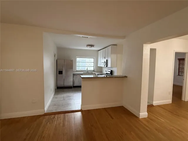a view of a kitchen with a sink and a refrigerator