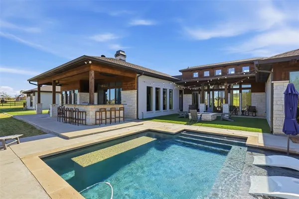 a view of a house with swimming pool and porch