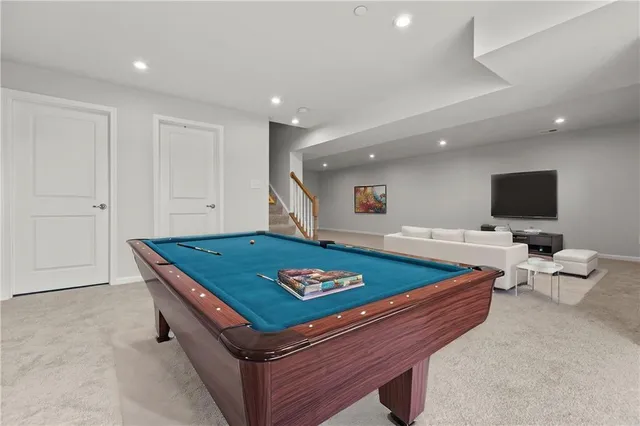 a room with furniture pool table and a flat screen tv