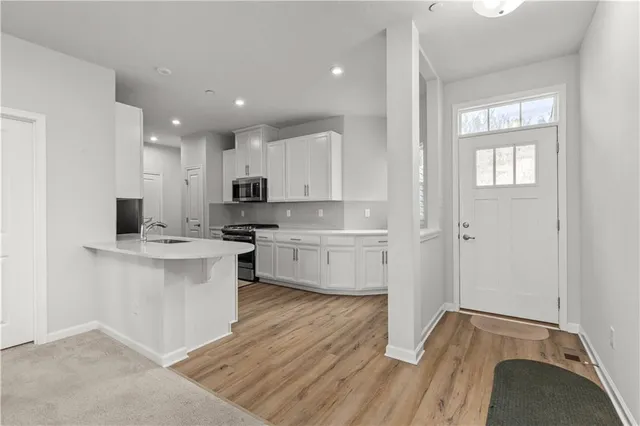 a kitchen with white cabinets and appliances