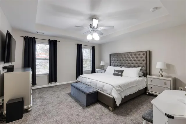 a bedroom with a bed couch and a flat tv screen