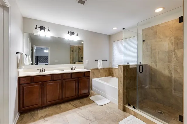 a spacious bathroom with a bathtub shower sink mirror and toilet