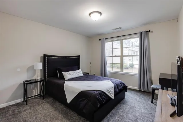 a bedroom with a bed and a flat tv screen on a dresser