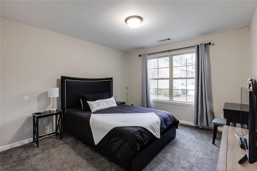 1561 Trailview Way Northeast Atlanta, GA 30329 - Photo 28 of 38 a bedroom with a bed and a flat tv screen on a dresser