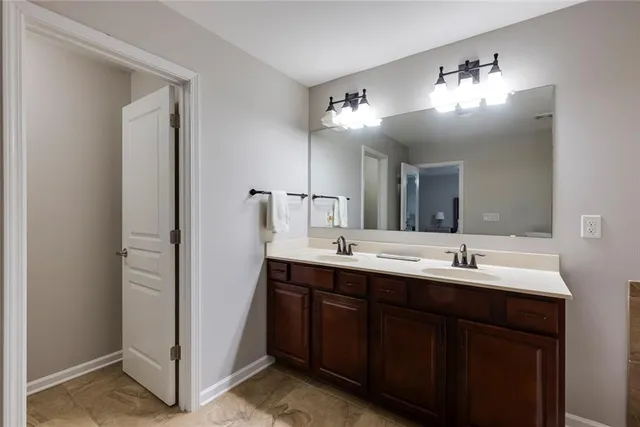 a bathroom with double vanity and a mirror