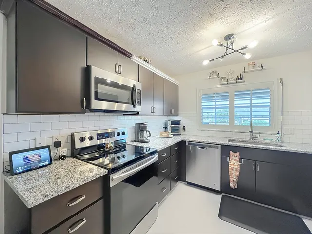 a kitchen with stainless steel appliances granite countertop a stove and cabinets