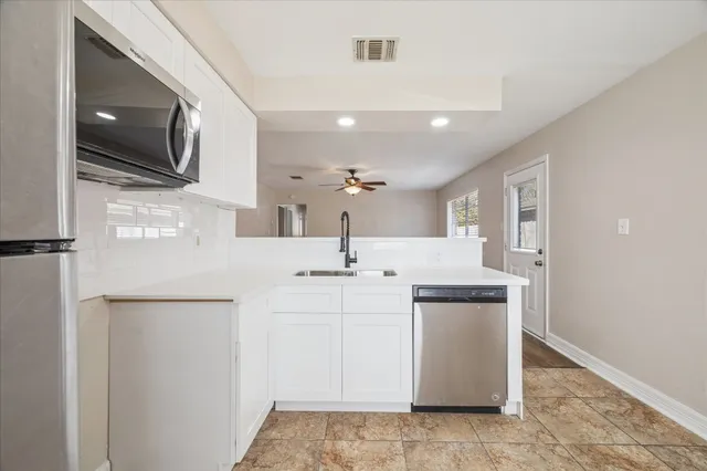 a kitchen with stainless steel appliances a sink a stove and a refrigerator