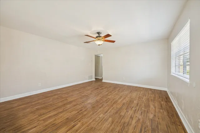 wooden floor in an empty room with a window