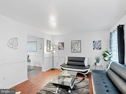 a living room with furniture and a wooden floor