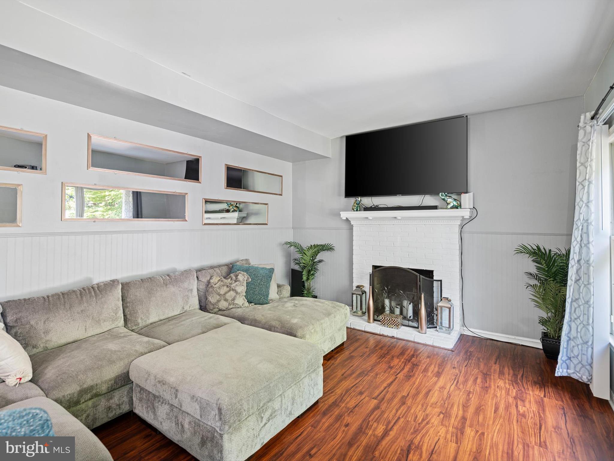 103 Osprey Court Camden Wyoming, DE 19934 - Photo 8 of 34 a living room with furniture a flat screen tv and a fireplace