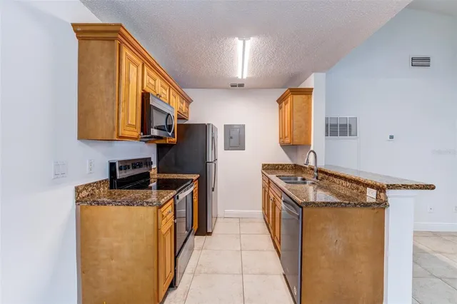 a kitchen with stainless steel appliances granite countertop a stove a sink and a microwave