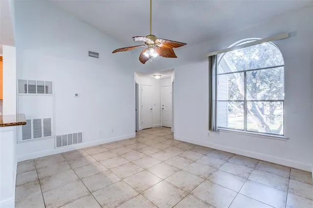 a view of an empty room with windows and fan