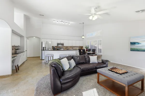 a living room with furniture kitchen view and a chandelier
