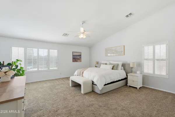 a spacious bedroom with a bed and a window