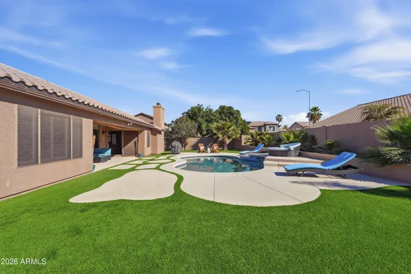 a view of a house with swimming pool and a yard