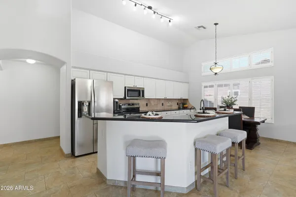 a kitchen with refrigerator and chairs