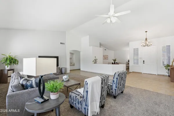 a spacious bedroom with a bed a couch and a potted plant