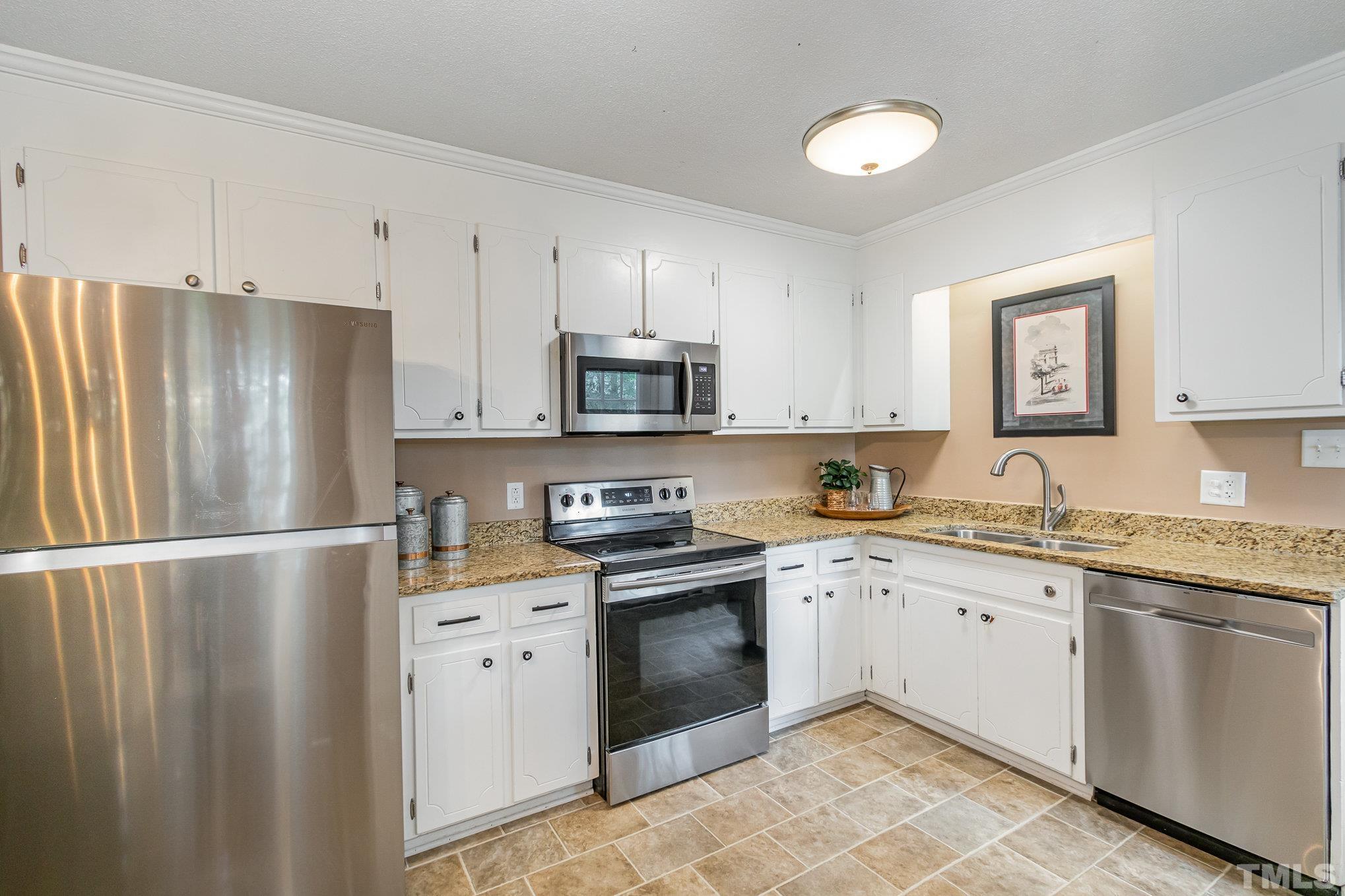 1712 Riverview Road Raleigh, NC 27610 - Photo 13 of 27 a kitchen with stainless steel appliances granite countertop a refrigerator sink and cabinets