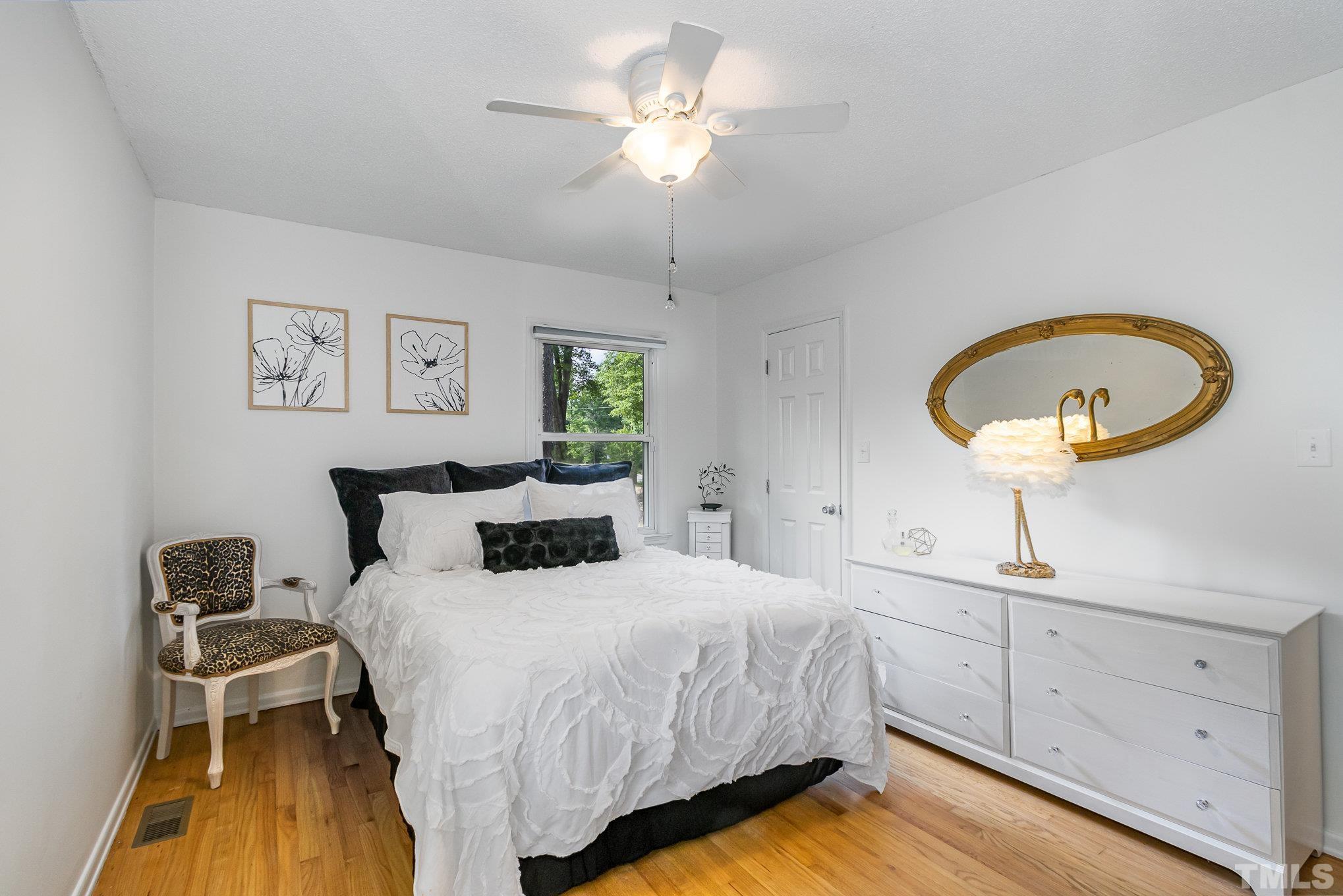 1712 Riverview Road Raleigh, NC 27610 - Photo 14 of 27 a bedroom with a bed and a chandelier