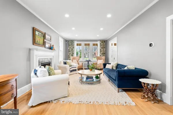 a dining room with furniture a chandelier and wooden floor