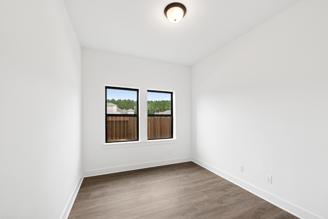 8731 Mancos Valley Porter, TX 77365 - Photo 14 of 46 an empty room with wooden floor and windows
