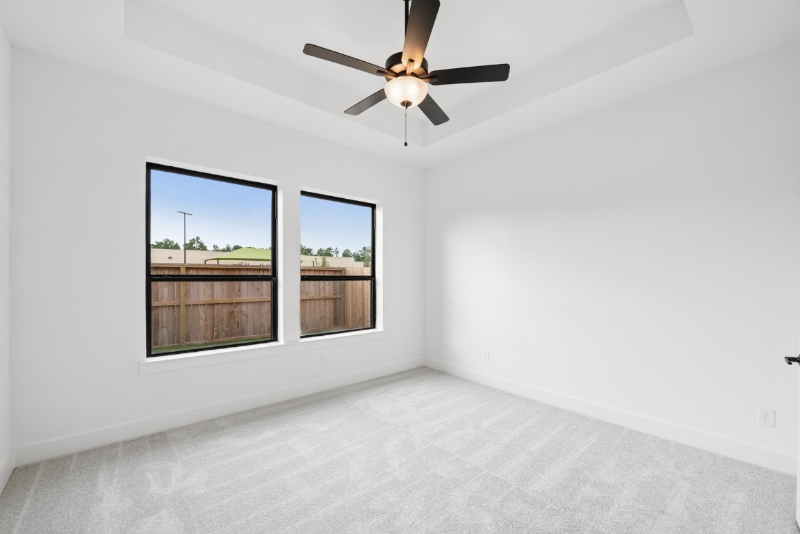 8731 Mancos Valley Porter, TX 77365 - Photo 30 of 46 an empty room with chandelier fan and windows