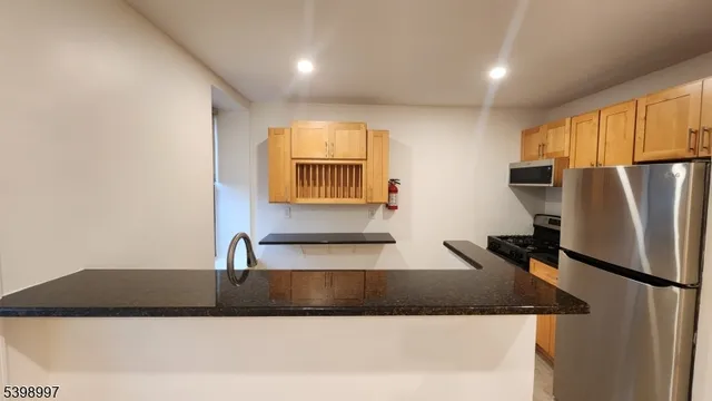 a kitchen with stainless steel appliances granite countertop a refrigerator and a stove top oven