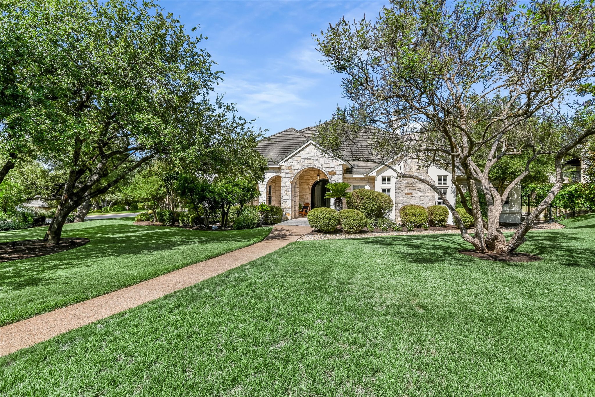 French provincial home with stone siding and a front yard
