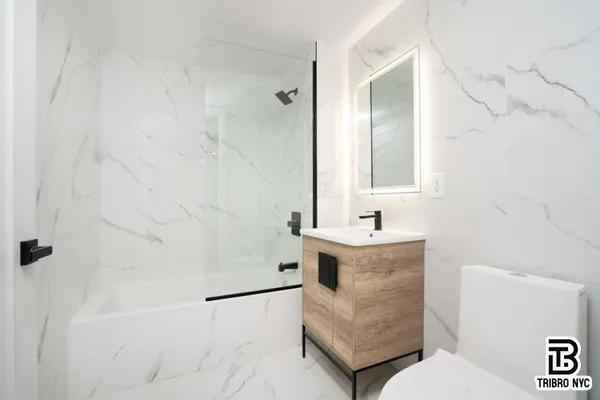 a bathroom with a sink a toilet and shower