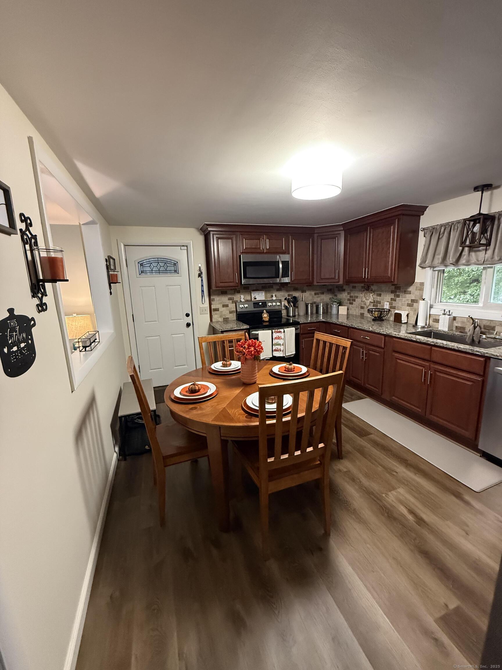 158 Monroe Avenue Waterbury, CT 06705 - Photo 4 of 12 a dining room with kitchen island a table and chairs in it
