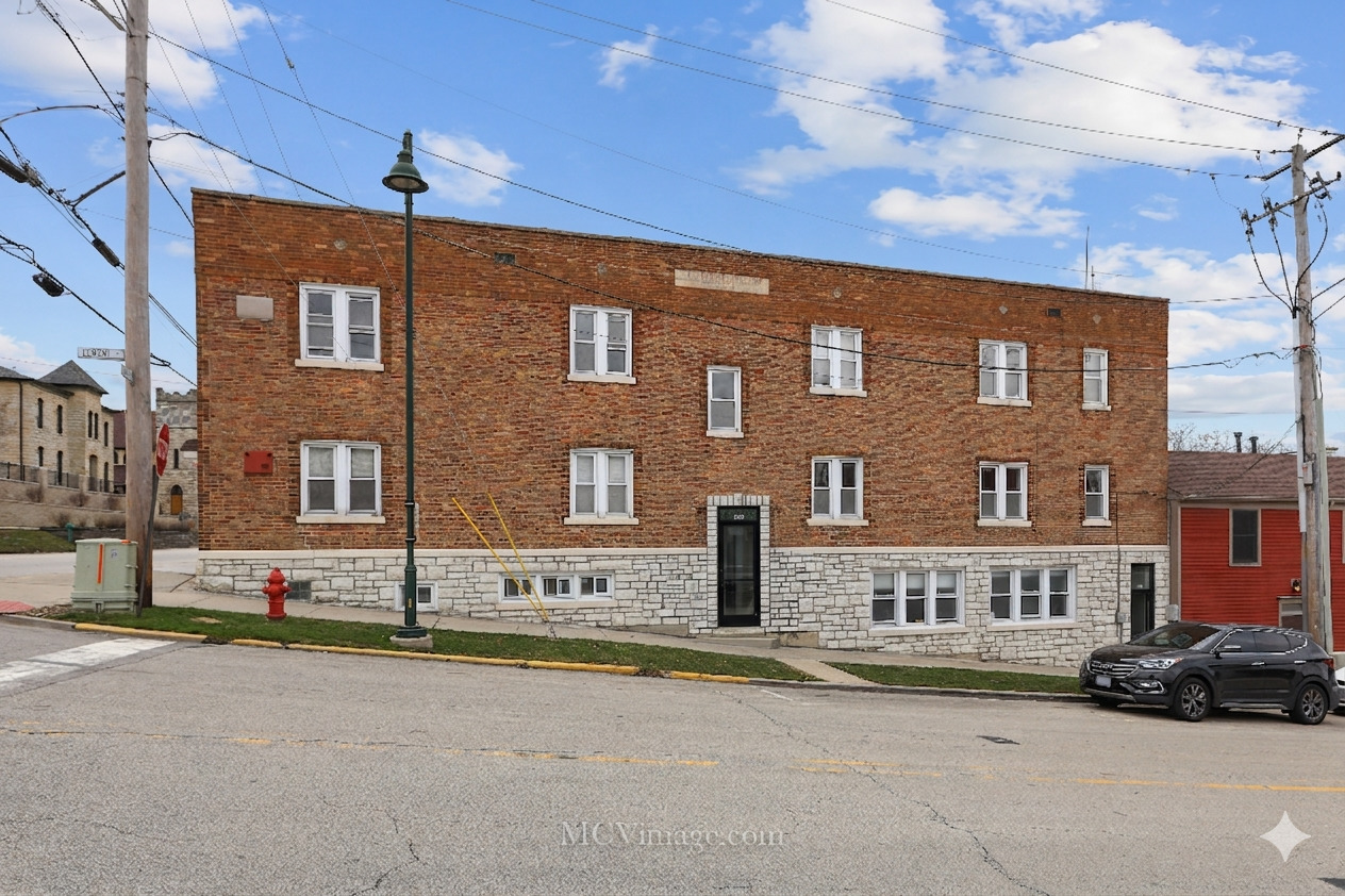 224 Lemont Street, Unit 5 Lemont, IL 60439 - Photo 1 of 21 a front view of a building with lot of cars and trees