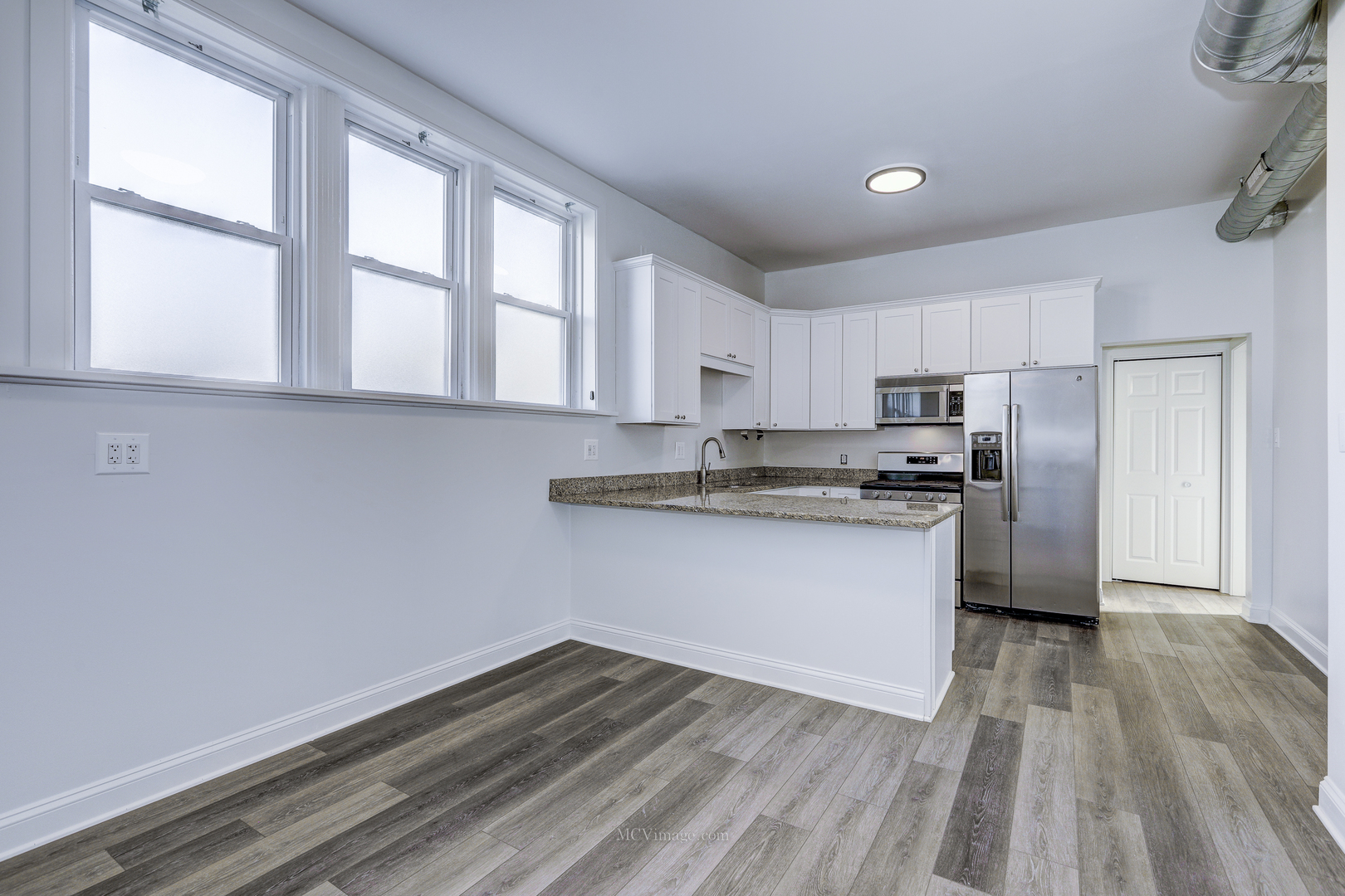 224 Lemont Street, Unit 5 Lemont, IL 60439 - Photo 4 of 21 a kitchen with granite countertop white cabinets and wooden floor