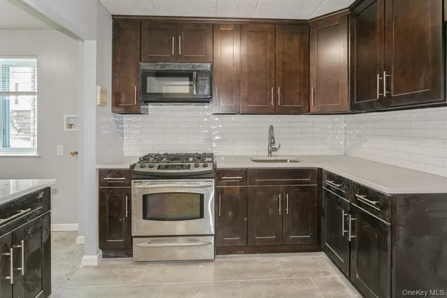 a kitchen with sink a microwave and cabinets