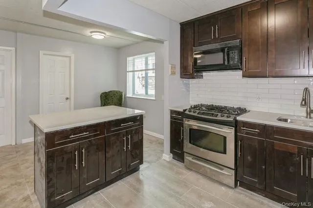 a kitchen with stainless steel appliances granite countertop a stove and a microwave