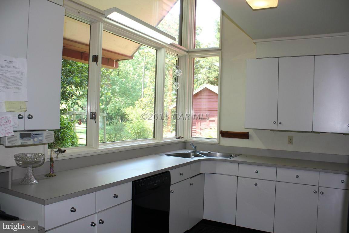 8579 Riggin Road Mardela Springs, MD 21837 - Photo 30 of 45 a kitchen with stainless steel appliances white cabinets a sink and a large window