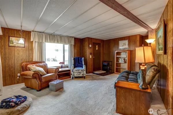 a living room with furniture a flat screen tv and a window