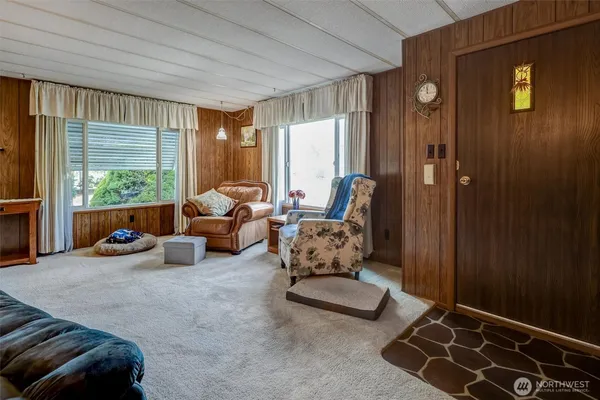 a living room with furniture chess table and a large window