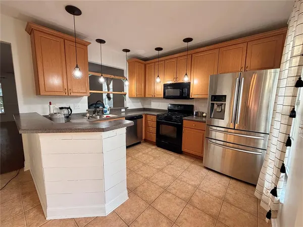 a kitchen with stainless steel appliances granite countertop a refrigerator sink stove microwave and cabinets