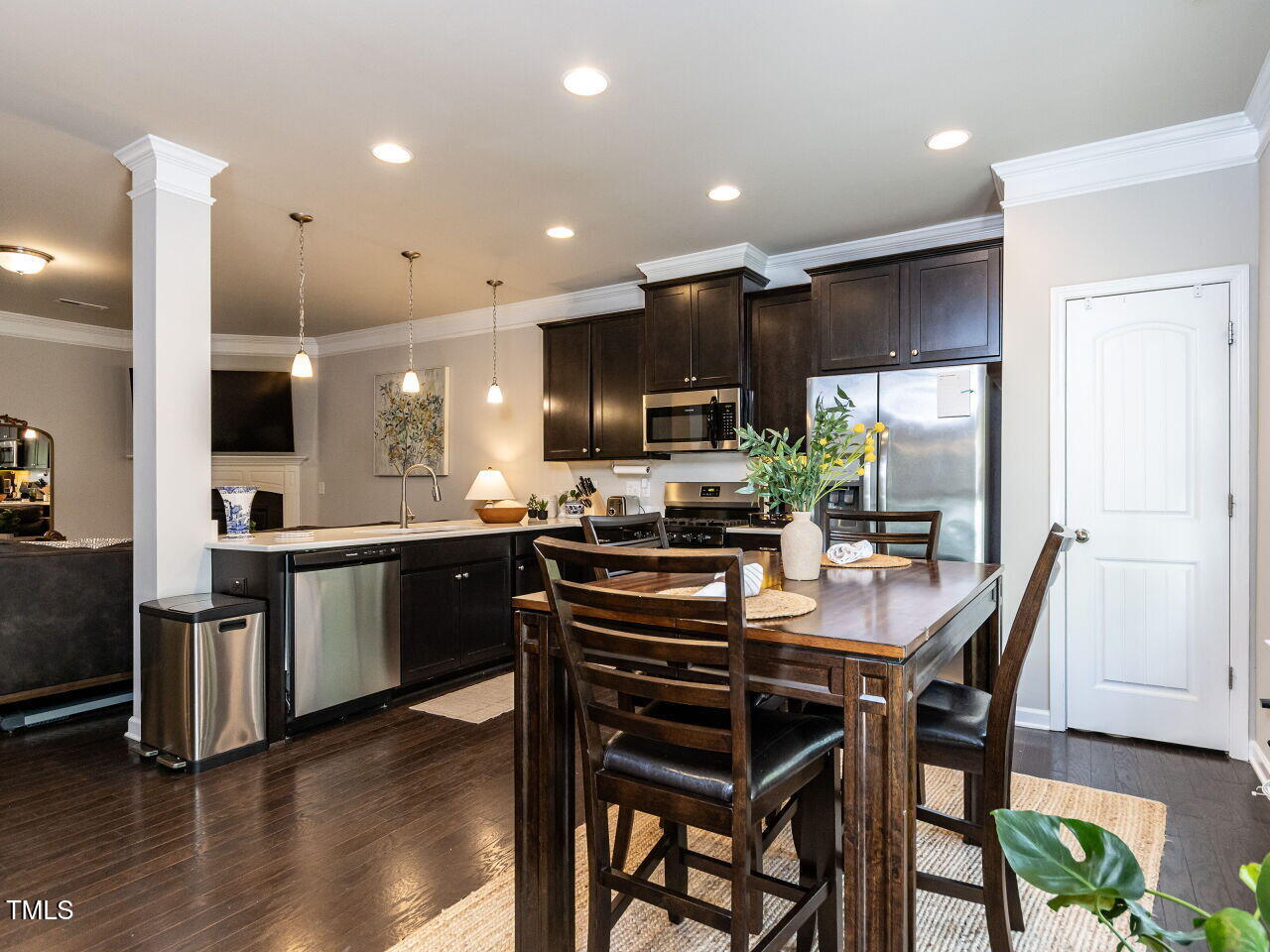 6341 Grace Lily Drive Raleigh, NC 27607 - Photo 6 of 29 a kitchen with stainless steel appliances kitchen island granite countertop a stove a sink a microwave a dining table and chairs