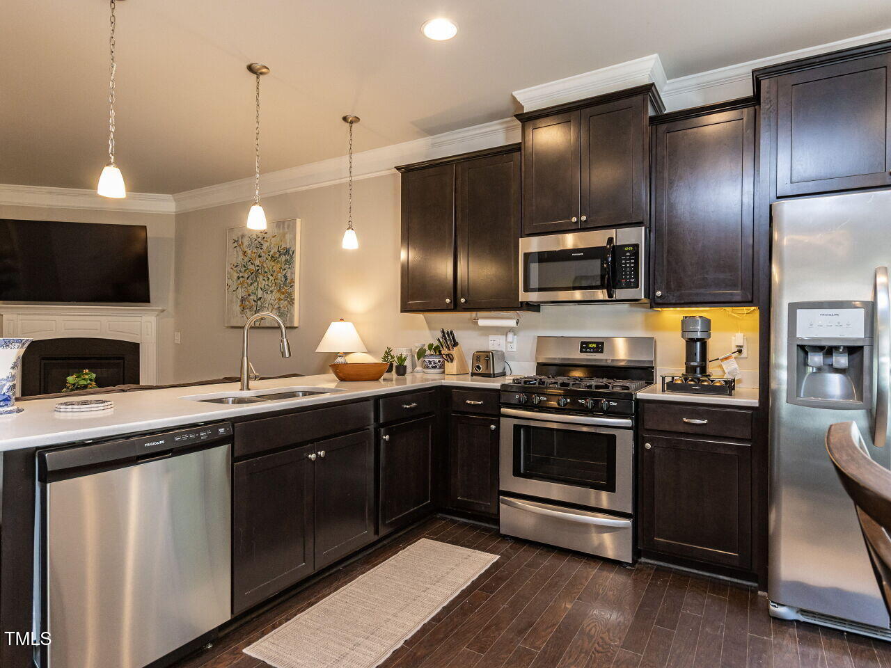 6341 Grace Lily Drive Raleigh, NC 27607 - Photo 7 of 29 a kitchen with stainless steel appliances kitchen island granite countertop a stove a sink and a microwave