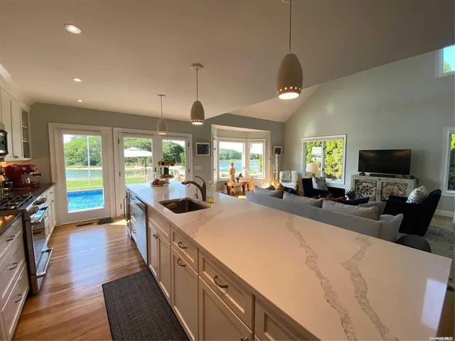 a large kitchen with kitchen island a large counter top space a sink a window and a chandelier