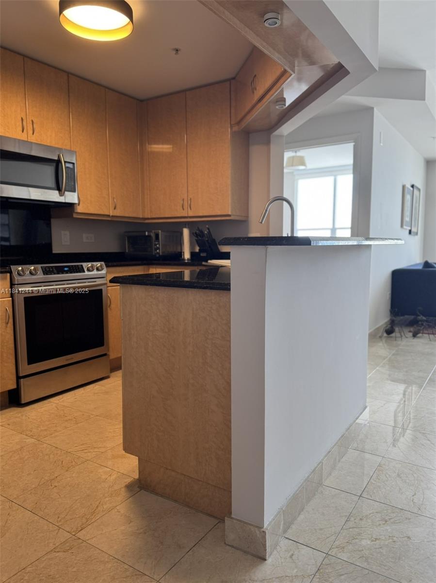 801 Brickell Key Boulevard, Unit 2705 Miami, FL 33131 - Photo 2 of 14 a kitchen with stainless steel appliances granite countertop a sink and a stove